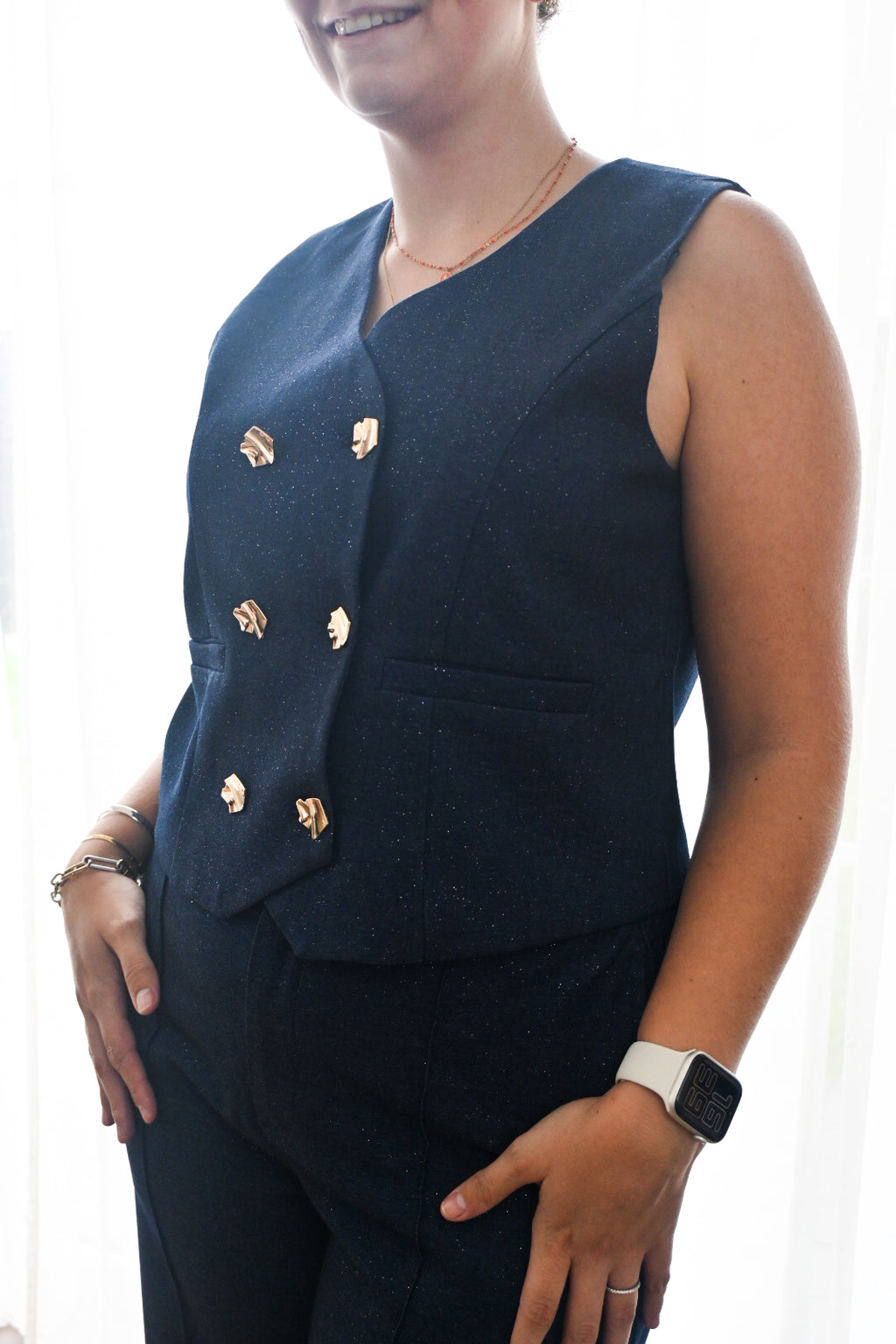 Glitter vest met gouden buttons.